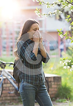 Woman blowing nose because of spring pollen allergy