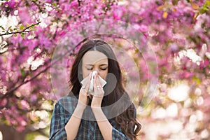 Woman blowing nose because of spring pollen allergy