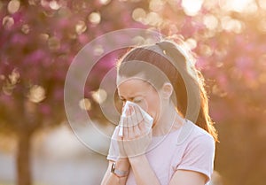 Woman blowing nose because of spring pollen allergy