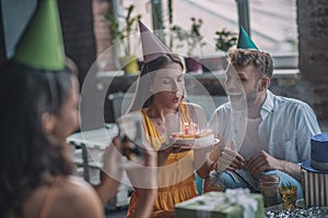 Woman blowing out candles on her birthday cake