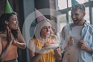 Woman blowing out candles on her birthday cake