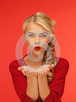 Woman blowing something on the palms of her hands