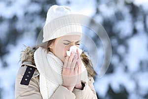 Woman blowing in a tissue in a cold snowy winter photo
