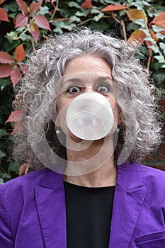 Woman blows bubbles with chewing gum