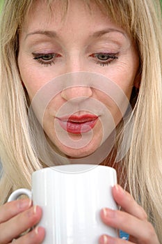 The woman blows in a mug