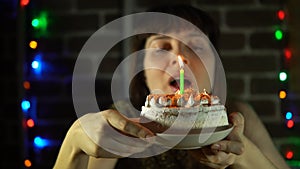 Woman blows out the candles on the cake