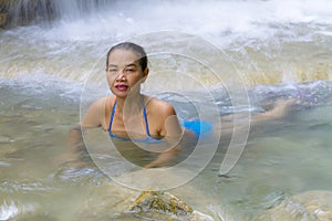 Woman with blue bikini play water at Erawan Waterfall