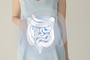 Woman in blue clothes holding virtual intestine in hand. Handrawn human organ, detox and healthcare, healthcare hospital service photo