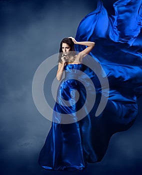 Woman in blue dress with flying silk fabric