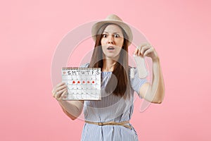 Woman in blue dress, hat holding sanitary napkin, tampon female periods calendar, checking menstruation days isolated on