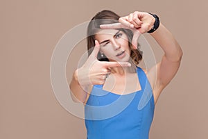 Woman in blue dress showing perspective frame or crop photo