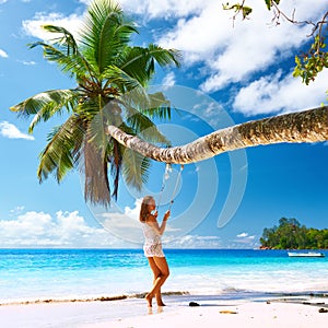 Woman in blue dress swinging at beach