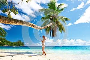 Woman in blue dress swinging at beach