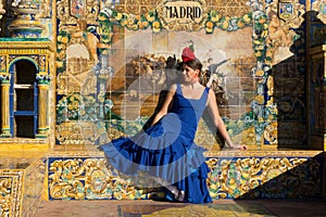 The woman with blue flamenco dress sitting in Plaza de Espana photo