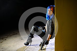 woman with blue hair holding two guns and looking as killer