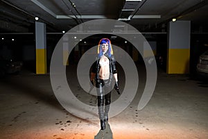 woman with blue hair holding two guns and looking as killer in underground parking