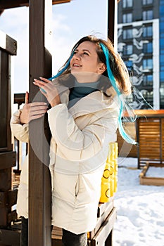 Woman With Blue Hair Leaning Against Wooden Structure