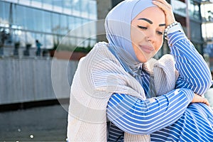 a woman in a blue hijab enjoys a vacation in nature. City walk in the park