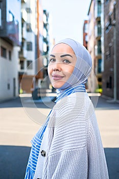 a woman in a blue hijab walks in a modern city. Lunch break in the city