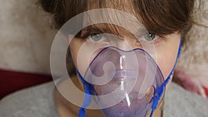 Woman in a blue hospital mask. Inhale vapors from the respiratory tract into the lungs. Cough treatment. A sick girl in