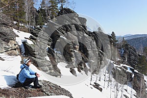 Woman in a blue jacket, sitting on a mountainside, Altai, Russia