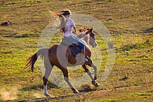 Woman in blue jeans riding a horse