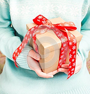 Woman in blue knitted sweater with a gift.