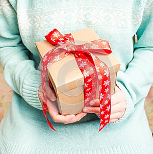 Woman in blue knitted sweater with a gift.