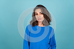 Woman in a blue knitted sweater and natural make-up, curly short hair