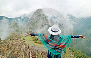 Woman in Blue Poncho Being Impressed by the Amazing Ancient Inca Citadel of Machu Picchu, UNESCO World Heritage Site in Peru