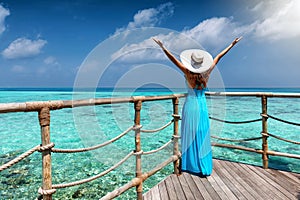 Woman in blue summer dress enjoys the view to the Indian Ocean