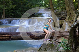 Woman with blue swimsuit sit at Erawan Waterfall and natural