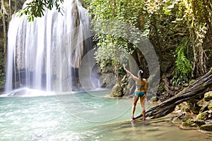 Woman in blue swimsuit stand  at  Erawan Waterfall and natural