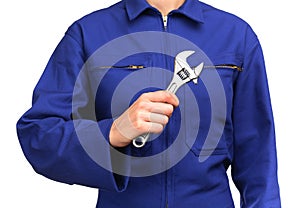 Woman in blue work uniform holding a monkey wrench