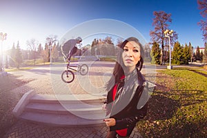 Woman and BMX cyclist doing a stunt jump