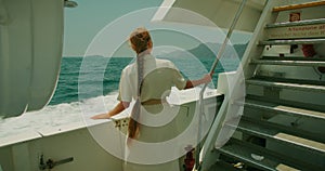 A woman on a boat looking out over the Mediterranean Sea. Essence of a summer sea adventure.