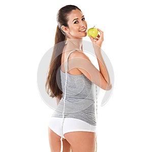 Woman, body and measurement with apple in studio on white background with tape for progress, weight loss and exercise
