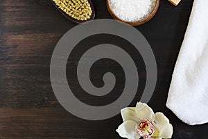 Woman body and skincare, bath and spa products, sea salt in bowl, white towel, beautiful flower, dry massage brush on black wooden