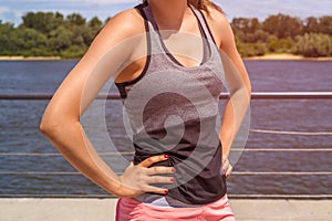 Woman body in sport wear by the river in sunny day.