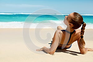 Woman Body In Summer. Girl In Bikini Tanning On Beach