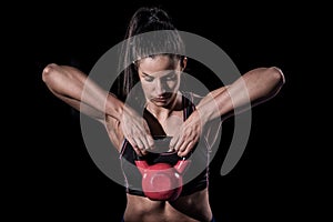 Woman bodybuilder lifting weight isolated over black background photo
