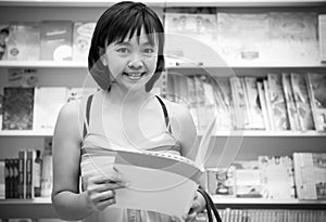 Woman with book in hands in a bookstore