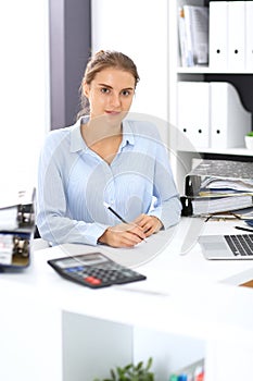 Woman bookkeeper or financial inspector calculating or checking balance, making report. Internal Revenue Service at work