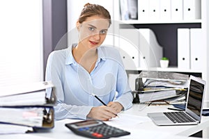 Woman bookkeeper or financial inspector calculating or checking balance, making report. Internal Revenue Service at work