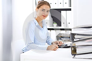 Woman bookkeeper or financial inspector calculating or checking balance, making report. Internal Revenue Service at work