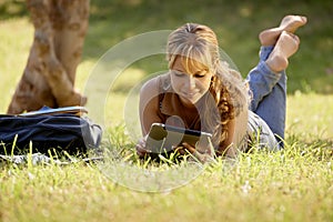 Woman with books and ipad studying for college test photo