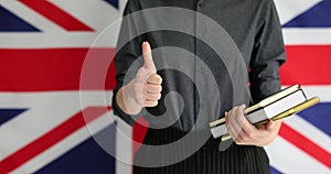 Woman with books shows gesture thumb-up after English lesson