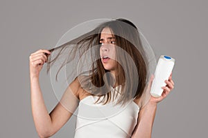 Woman with bootle shampoo loosing hair. Hair loss problem, baldness. photo