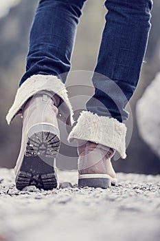 Woman in boots hiking along a rural path