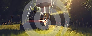 woman in boots and protective workwear cutting the grass with a riding lawnmower